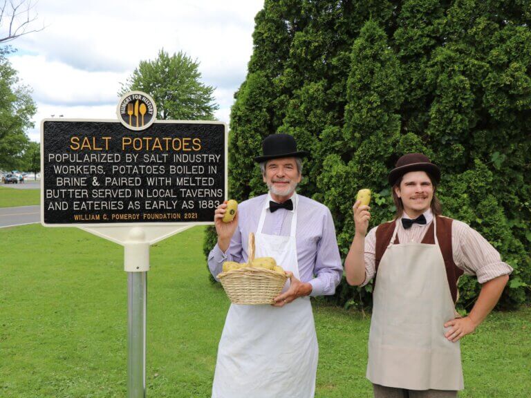 Historical reenactors of the Keefe brothers of Syracuse pose next to the Hungry for History marker for salt potatoes.