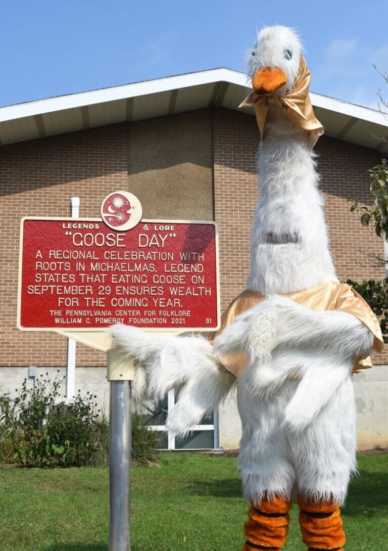 Legends & Lore marker for Goose Day with a goose mascot posing for the photo.